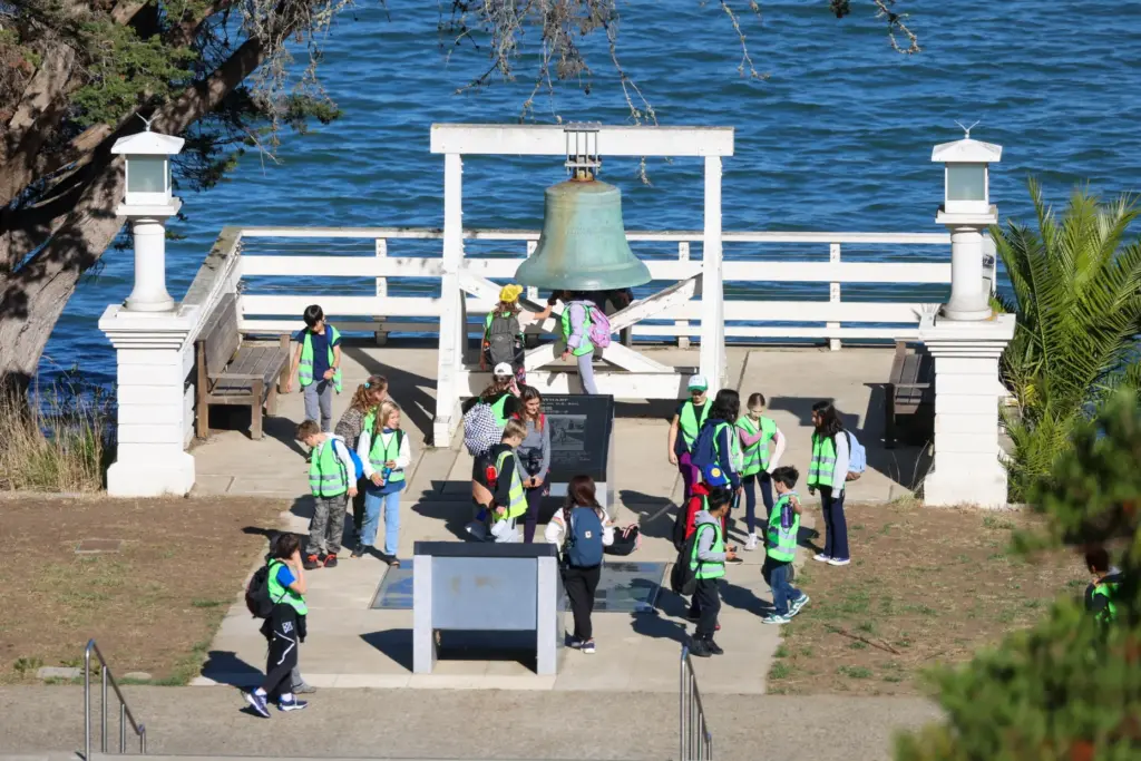 A group of students tour around the original fog-warning bell...
