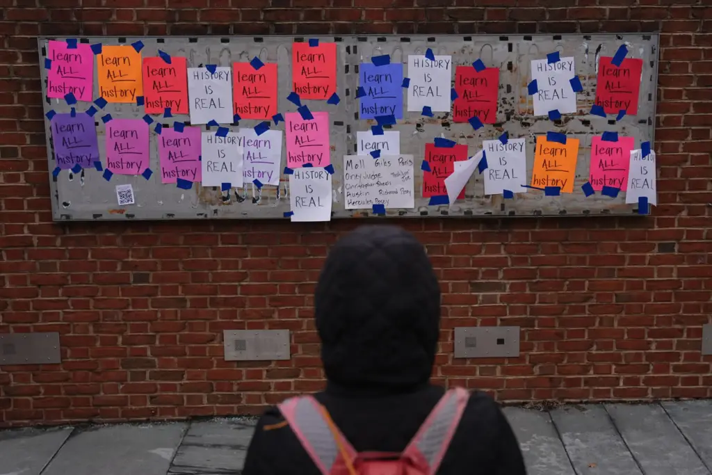 FILE – A person views posted signs on the locations...