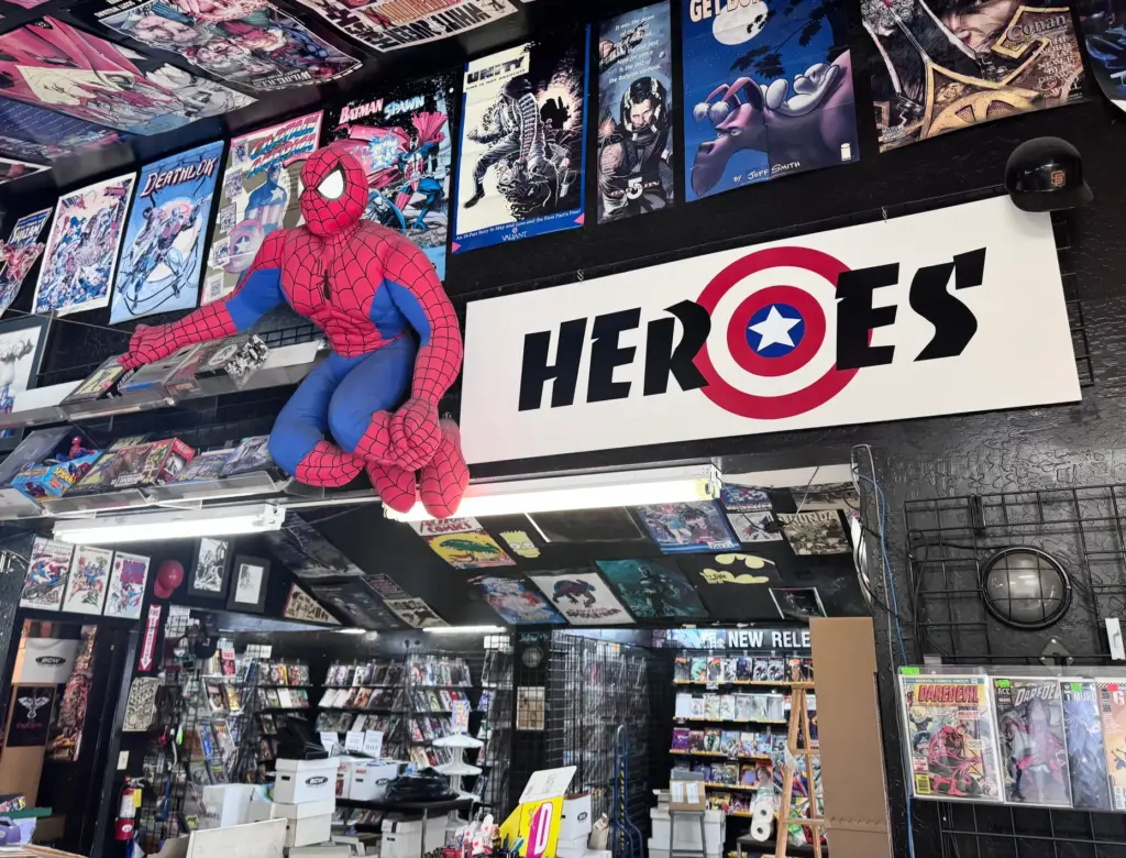 A stuffed Spider-Man perches on the wall at Heroes Comics...