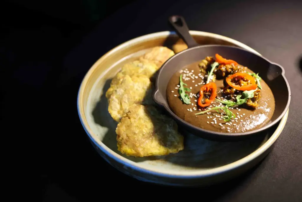 Black bean hummus served with a sourdough baguette, ripe plantain...