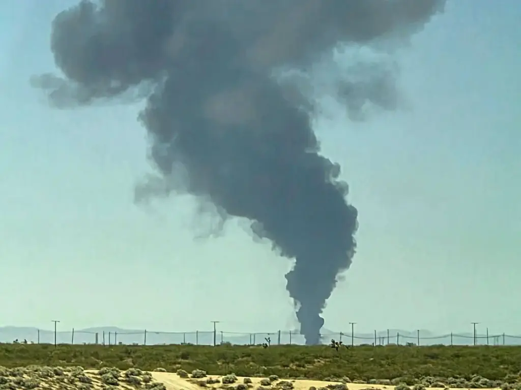Smoke plumes rise from a B-52 bomber that crashed shortly...