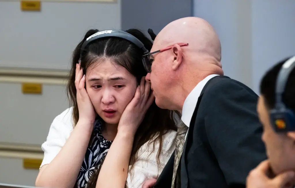 Tingfeng Liu, left, reacts during opening statements in court in...
