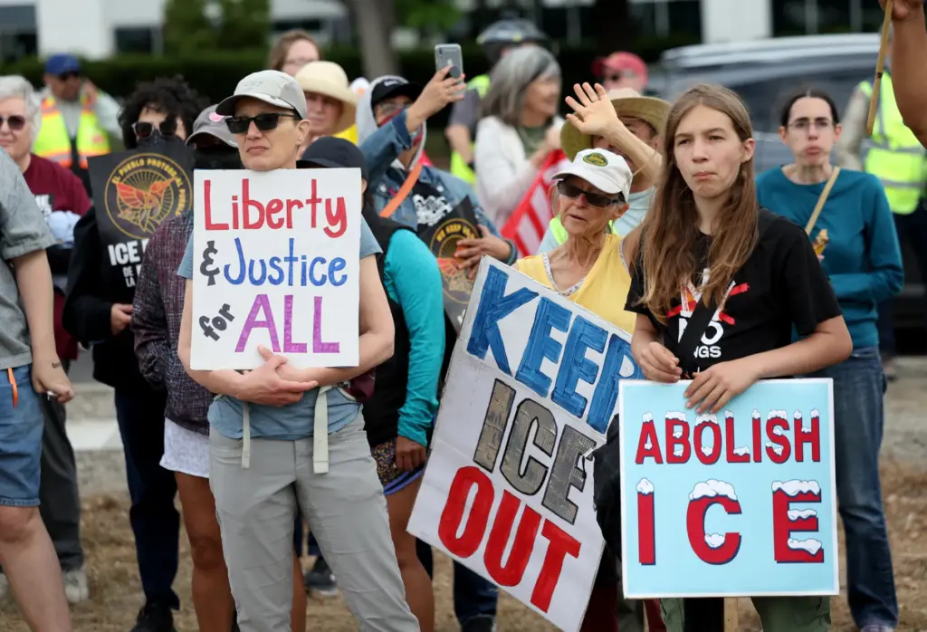 Gwen Rino, of Oakland, left, and others, take part in...
