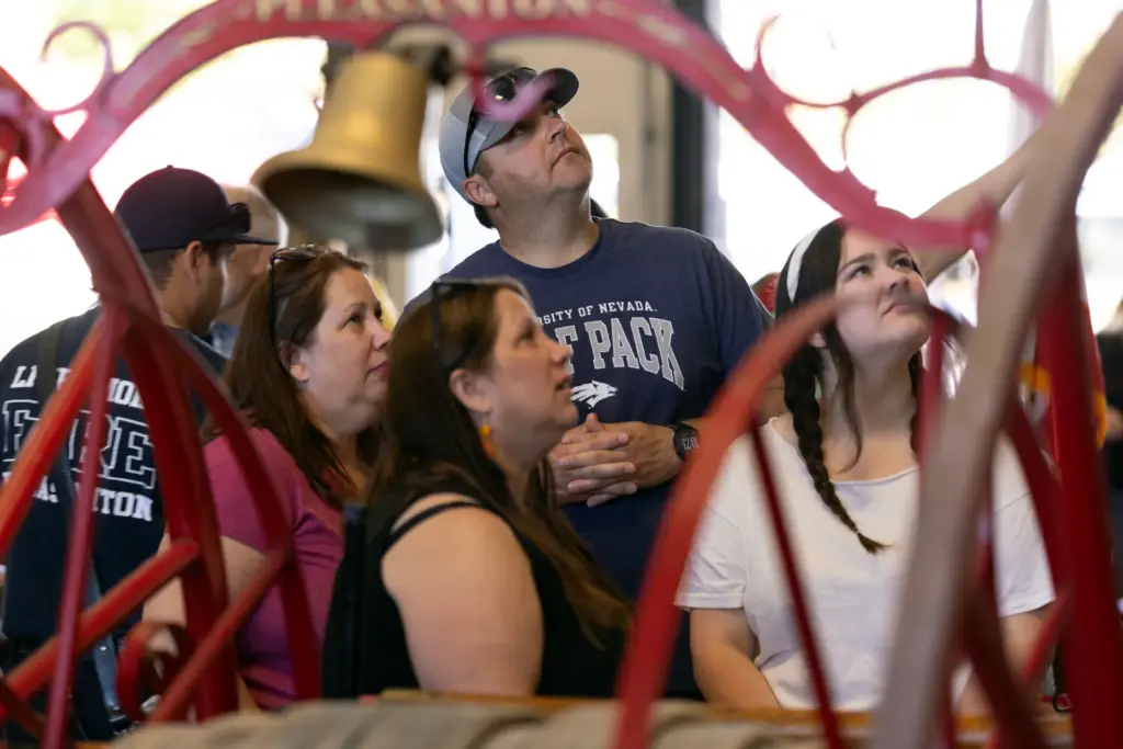Celebrants gaze up at the 4-watt light bulb that was...