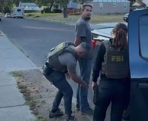 Bajun Mavalwalla II, center, being arrested by FBI agents in...