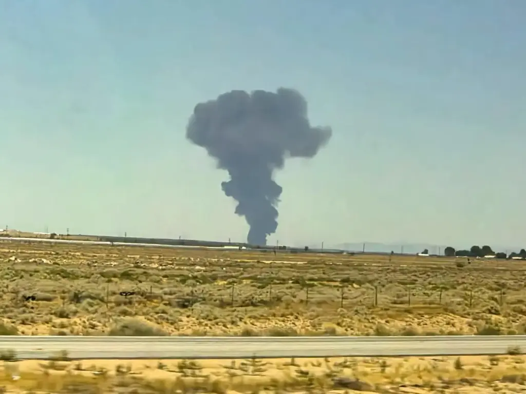 Smoke plumes rise from a B-52 bomber that crashed shortly...