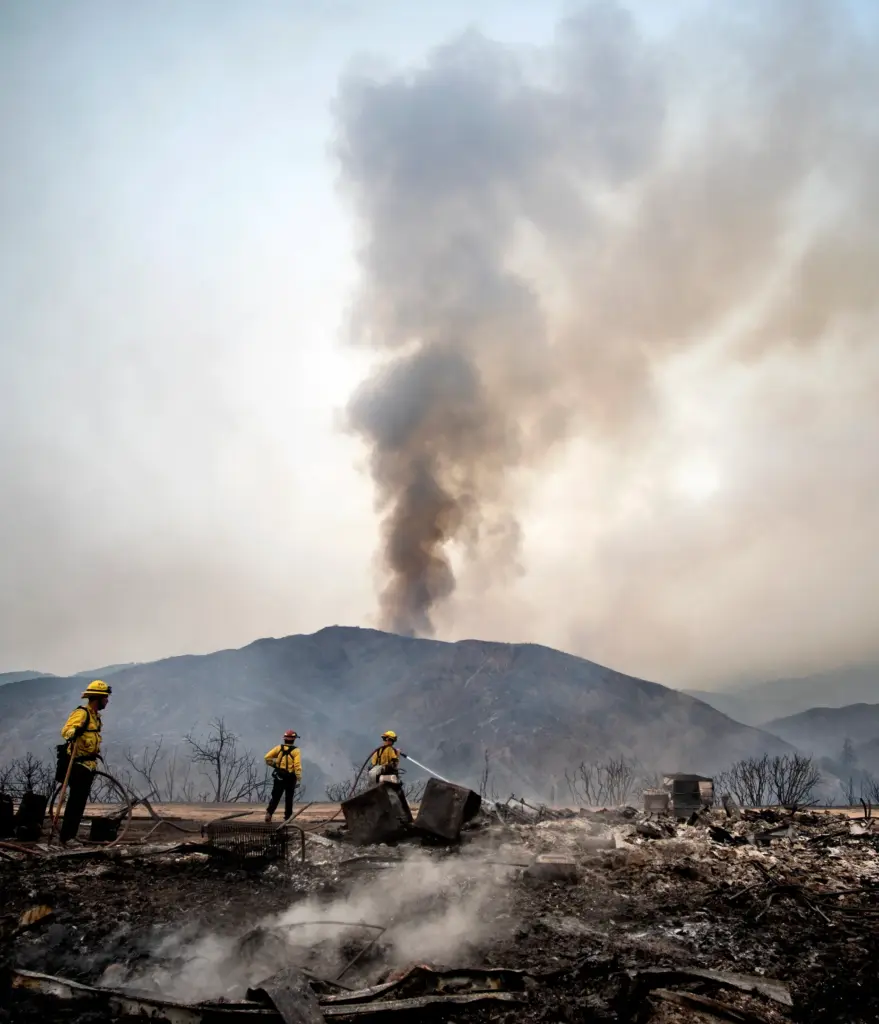 Fountain Valley, Caif., firefighters extinguish hot spots at a structure...