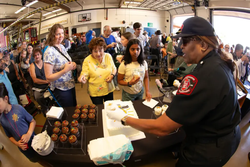Celebrants line up for cupcakes and layer cake at the...