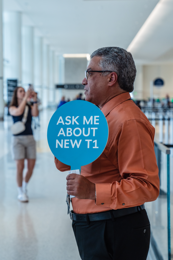 Mo Mokled holds a sign âAsk Me About New T1...