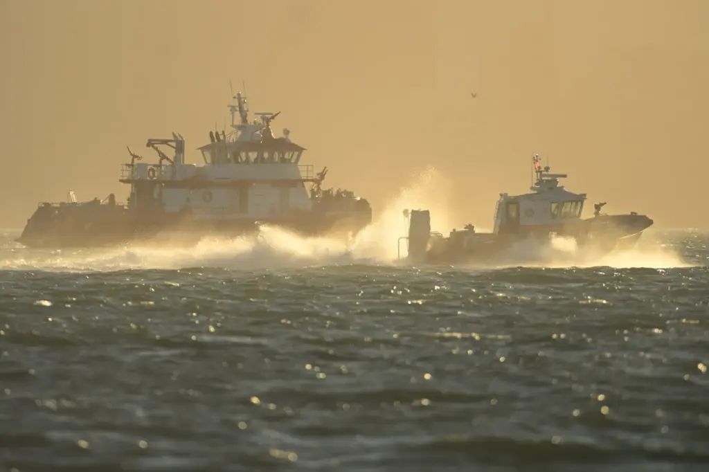 Search and rescue vessels look for missing victims after a...