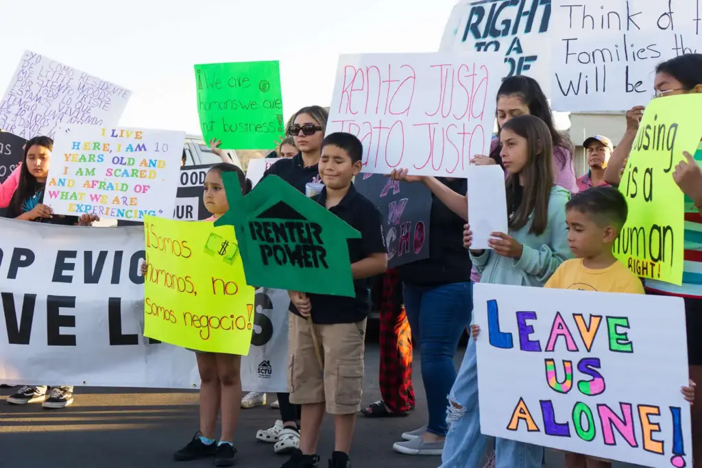 Residents of Little Woods Mobile Villa hold signs during a...