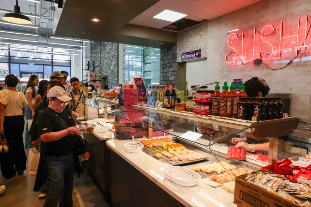 A customer serves herself sushi from the sushi buffet during...