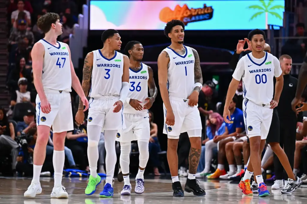 Golden State Warriors players walk onto the floor to play...