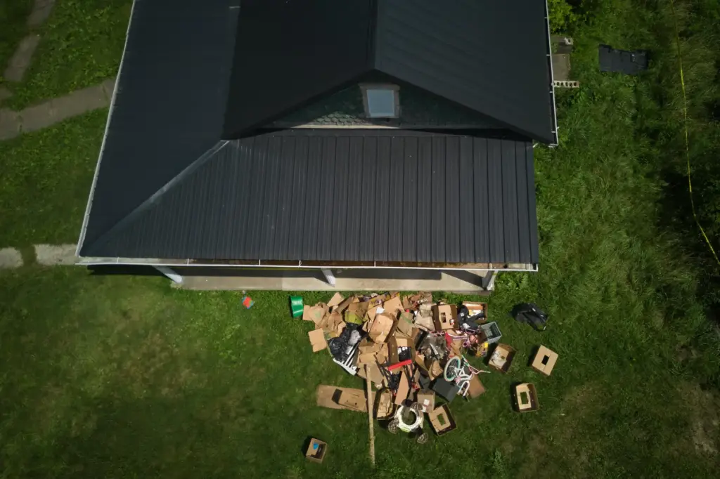 Debris is strewn on the front lawn of a home...