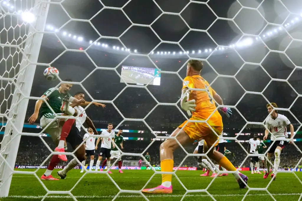 Mexico’s Cesar Montes, left, and England’s Jude Bellingham (10) battle...