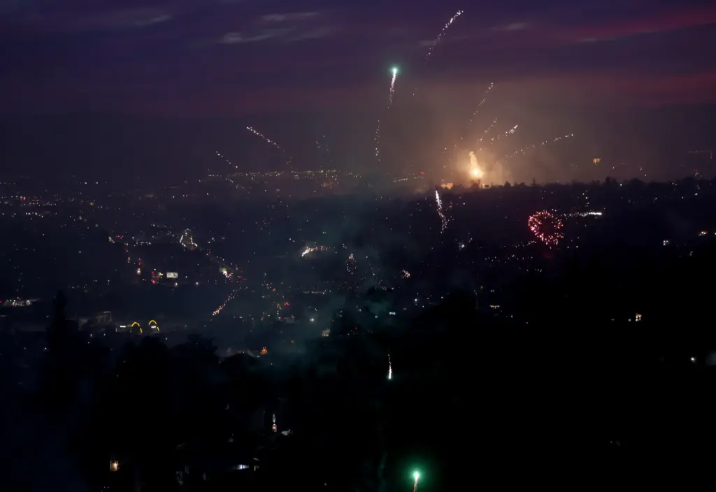 Illegal fireworks are seen from a hillside in East Oakland,...