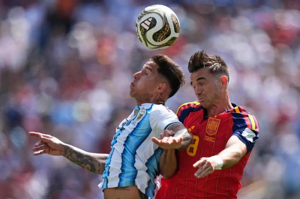 Argentina’s Enzo Fernandez (24) and Spain’s Fabian Ruiz (8) go...