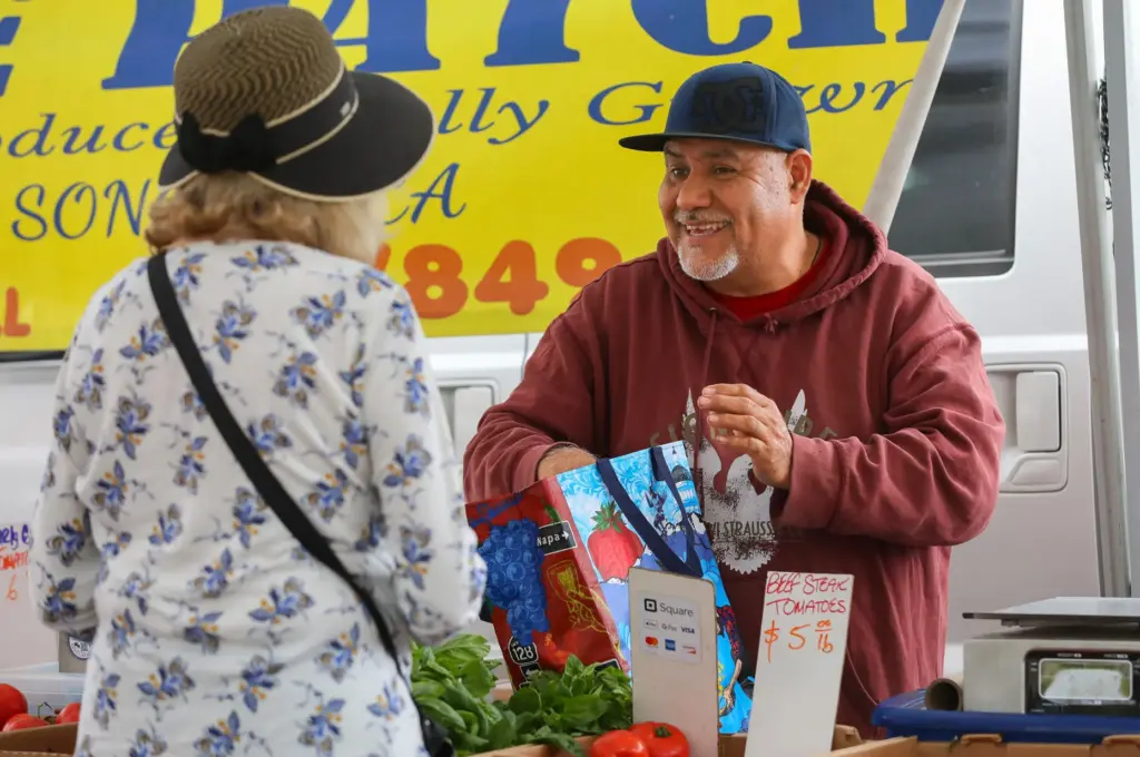 Fernando Calderon, right, owner of The Patch, packs Kathleen Eckertâs...