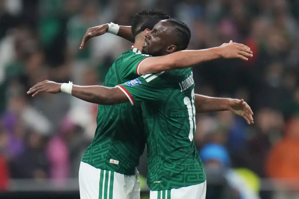 Mexico’s Raul Jimenez, left, celebrates with Julian Quinones after scoring...