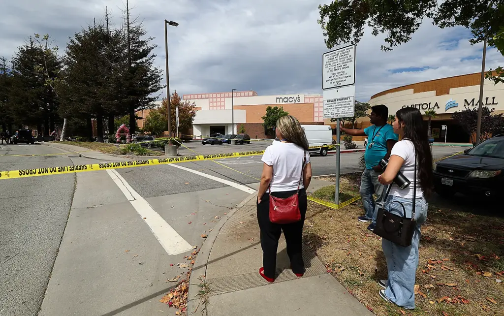 Employees of businesses at the Capitola Mall wait behind crime...