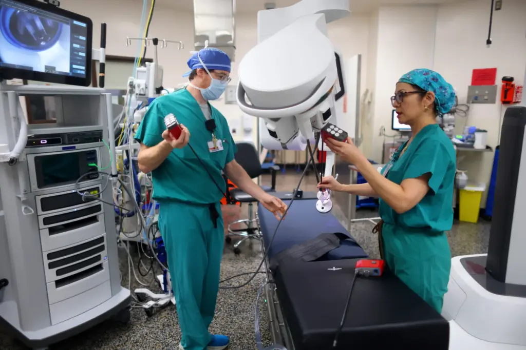 Robotics coordinator Max Bellmore, left, and Dr. Rita Kwan-Feinberg assemble...