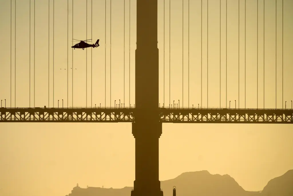 A helicopter flies past the Golden Gate Bridge while searching...