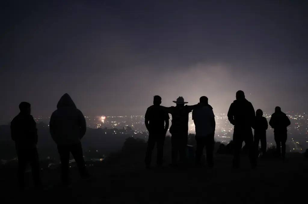 Local residents view illegal fireworks from a hillside in East...