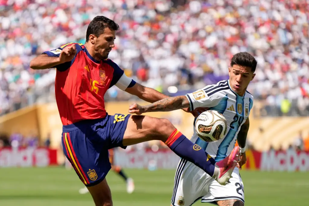 Spain’s Rodri, left, vies for the ball with Argentina’s Enzo...