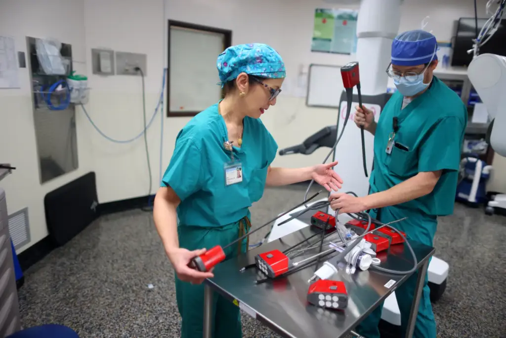 Dr. Rita Kwan-Feinberg, left, and robotics coordinator Max Bellmore, right,...