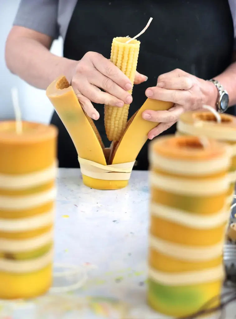 A worker pulls a corn candle out of its mold at Happy Organics' studio.