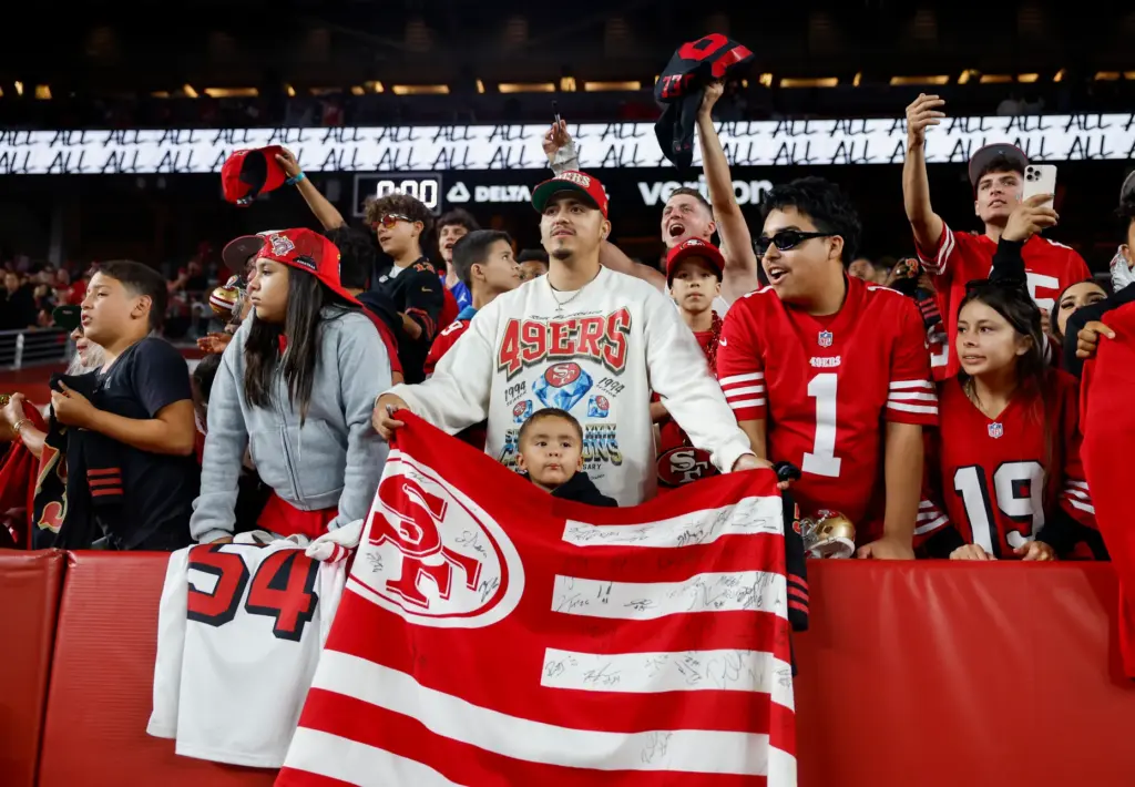 San Francisco 49ers fans yell at players as they leave...