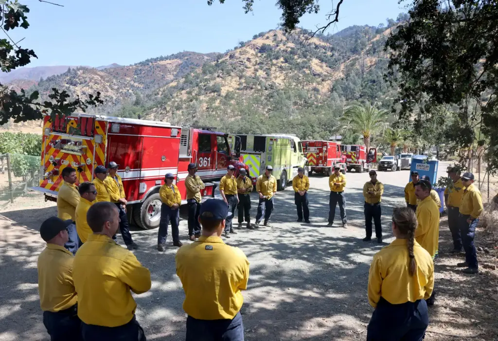 Firefighters from a various agencies gather for a briefing at...