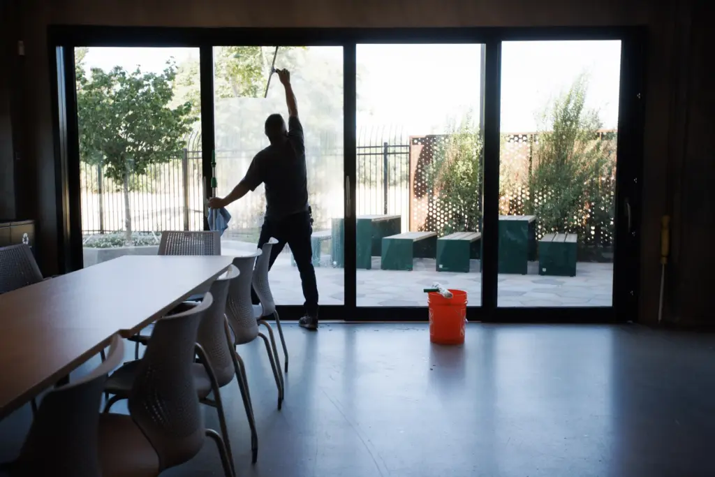 Janitor Gorge Rojas cleans windows in a common area at...