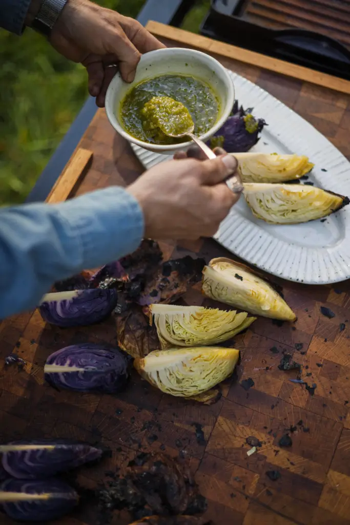 Lee Desrosiers spoons a spicy, tangy sauce made with chiles...