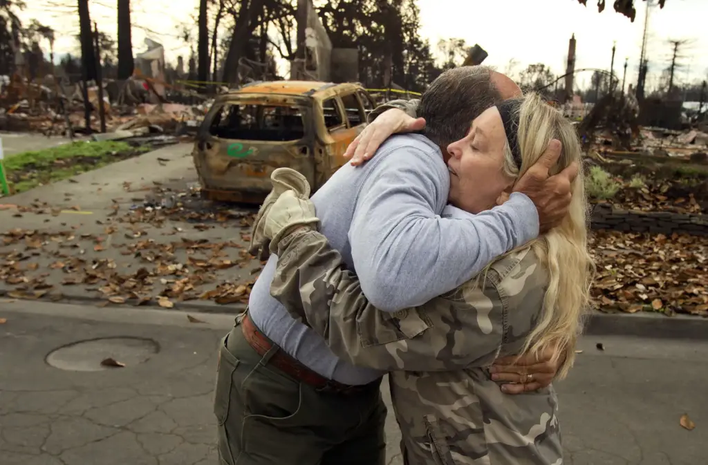Tom Tantarelli hugs neighbor Cyndy Silver on Miller Dr. between...