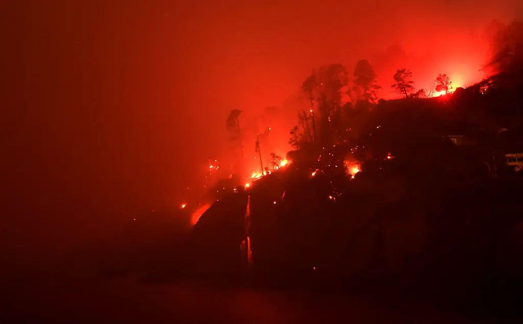 The Woodside Fire burns down to the Pacific Ocean north...
