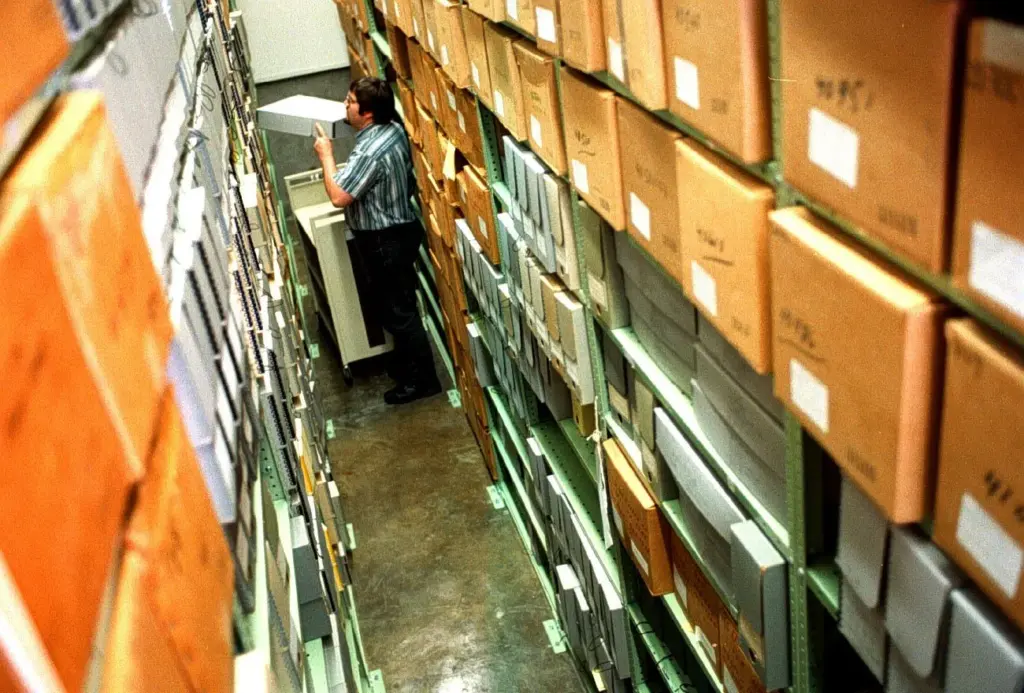 Archive Specialist Bill Greene stacks a file at the at...