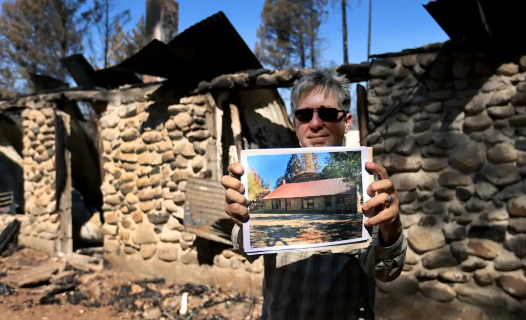 Biologist Jeff Alvarez displays a photograph of a historical cabin...