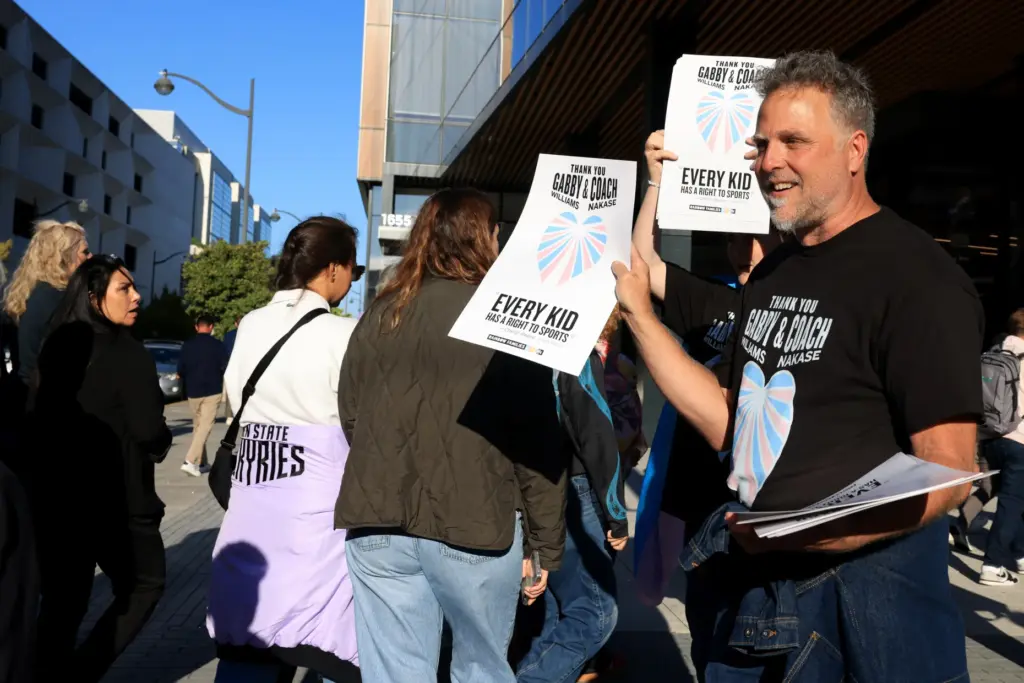 Golden State Valkyries fans and demonstrators hand out posters in...