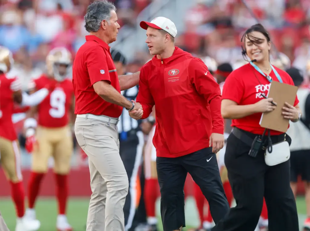 San Francisco 49ers' Christian McCaffrey (23) shakes hands with former...
