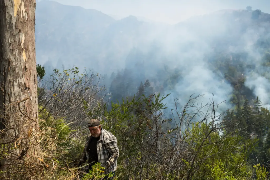 Saul Hernandez Gonzales cuts brush on a friend’s property as...