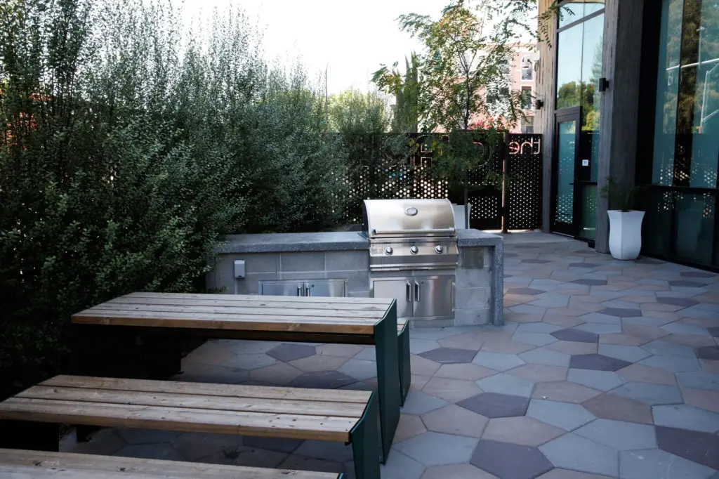 A patio area features benches and a barbecue grill at...