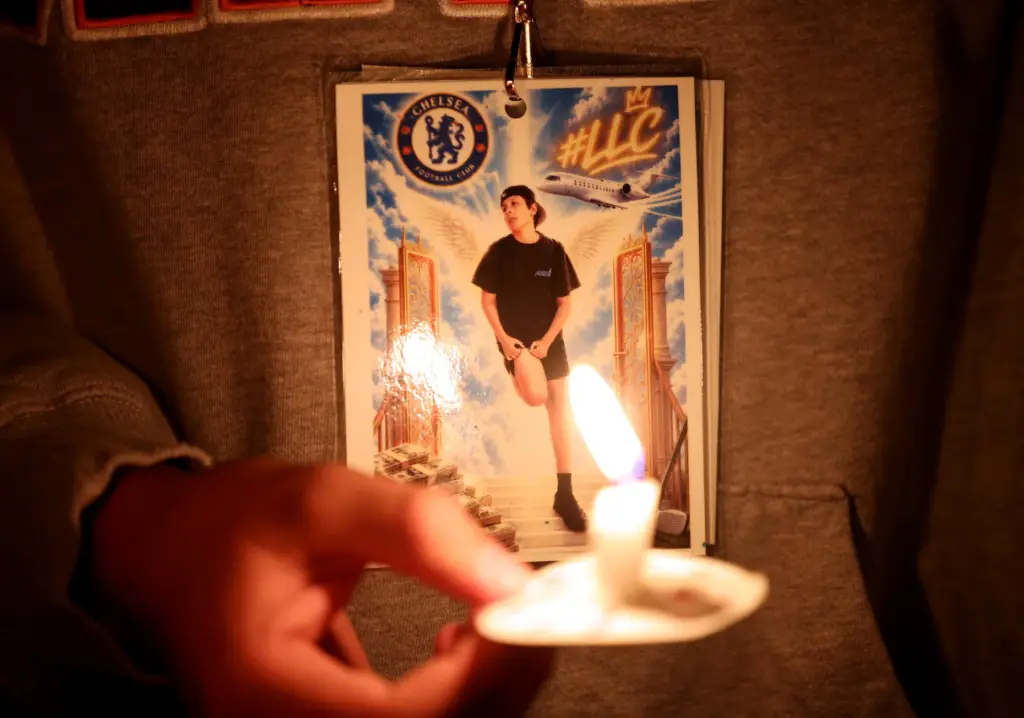 Students wear photos on a lanyard as they attend a...