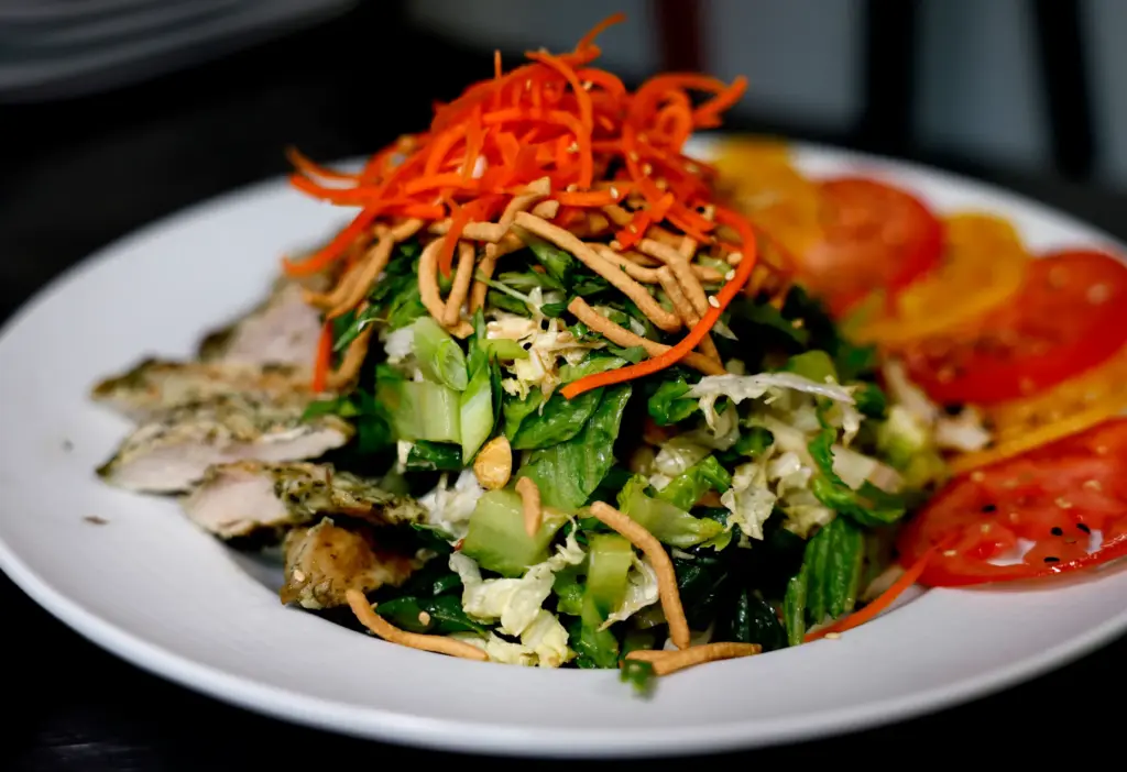 Asian Chicken Salad, made with Romaine lettuce, Napa cabbage, carrots,...