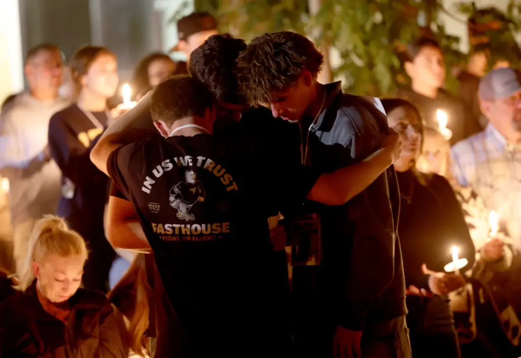 Students grieve at a vigil for seniors Dominic Ferrari, and...