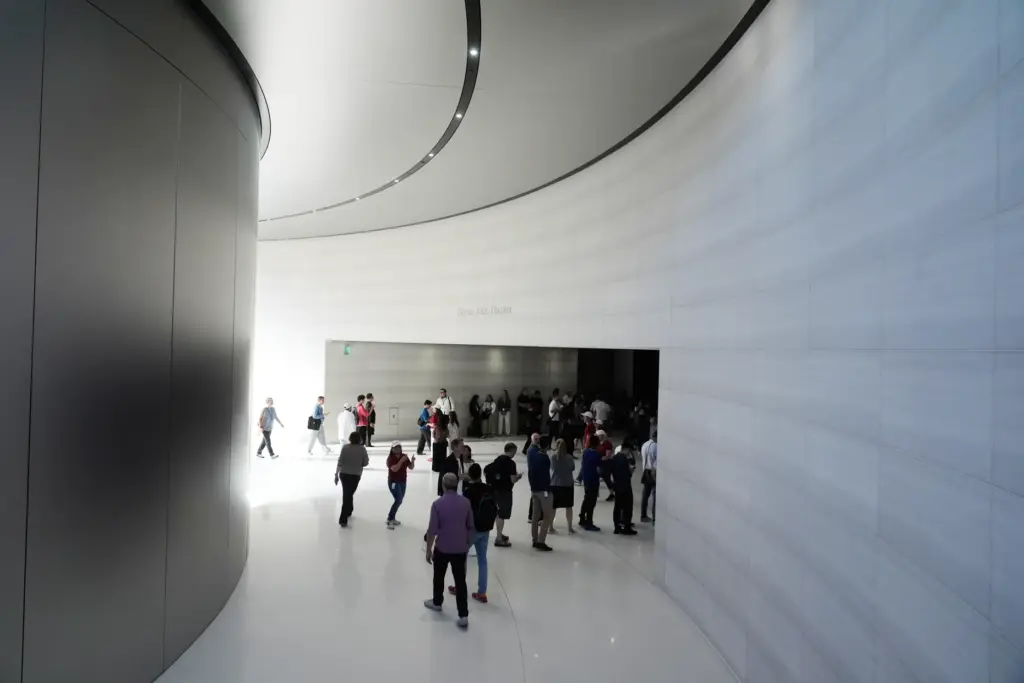 Attendees walk inside the Steve Jobs Theater before an announcement...