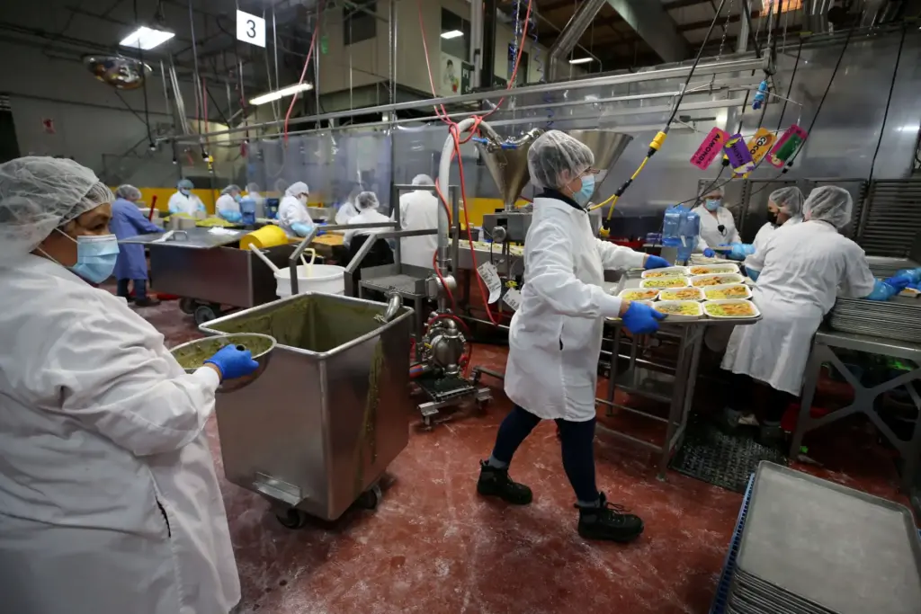 Employees prepare Indian Vegetable Korma frozen meals in the Amy’s...