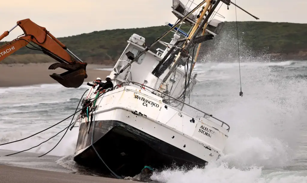 Personnel from a salvage crew wait to offload equipment from...