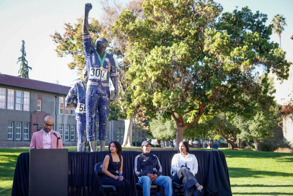 Dr. John Carlos, center, sits before speaking during a panel...