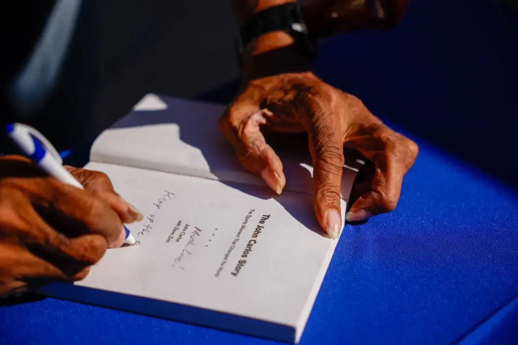 Dr. John Carlos signs a book titled âThe John Carlos...